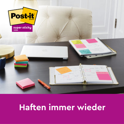 Auf dem Schreibtisch liegen ein Planer, ein Laptop, ein Stift und bunte 3M Deutschland GmbH Post-it® Super Sticky Notes im Großformat (liniert, 101 mm x 101 mm, 45 Blatt/Block), wobei die Notizen auf den Planerseiten befestigt und "Haften immer wieder" sichtbar sind.