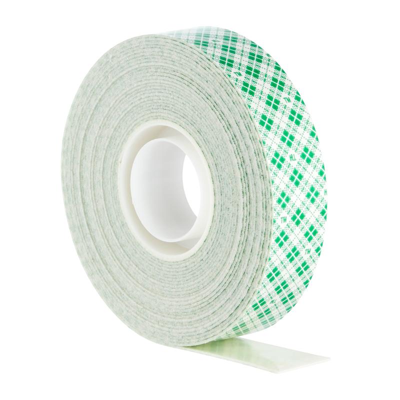 Le ruban de montage intérieur double face Scotch-FIX™ de 3M Deutschland GmbH a un noyau blanc avec un motif à carreaux verts et est représenté debout avec une petite partie du ruban adhésif.