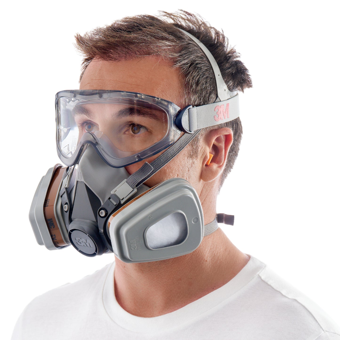 Un homme en chemise blanche porte la boîte de démarrage de protection 3M™ pour professionnels 1000MCWE - masque respiratoire, lunettes de protection et bouchons d'oreilles - de 3M Deutschland GmbH. La vue de côté montre les sangles du masque, le tout sur fond blanc.