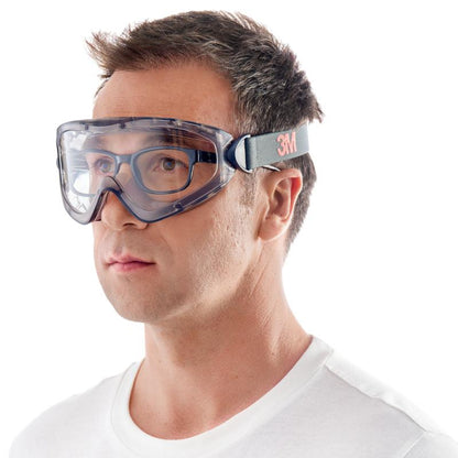 Un homme portant un t-shirt blanc à col rond porte les lunettes de protection 3M™ modèle 2891 avec Scotchgard™ Protector antibuée, ventilation indirecte et verre transparent de 3M Deutschland GmbH, présenté sur un fond blanc uni.