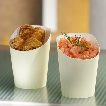 Deux gobelets à snack beige PAPSTAR To Go (Ø 7,5 cm, 0,16 l) de la société PAPSTAR sont placés côte à côte; l'un contient des bouchées frites, l'autre des crevettes à l'aneth. Les deux gobelets en carton écologiques sont posés sur une surface rayée.