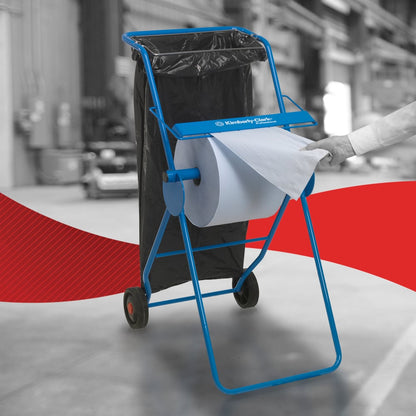 Eine Person benutzt ein WypAll® L30 Papierwischtuch von Kimberly-Clark GmbH von der extra breiten Großrolle auf einem blauen Spender mit Müllsack im Industrieumfeld-perfekt für industrielle Reinigungsaufgaben.