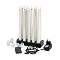 Un lot de 1 bougie LED pointue Duni GmbH de 27,8 cm, de couleur blanc chaud, est présenté avec élégance avec sa station de recharge noire, sa télécommande, son adaptateur secteur, son câble USB et ses capuchons blancs : l'idéal pour une décoration d'intérieur raffinée.