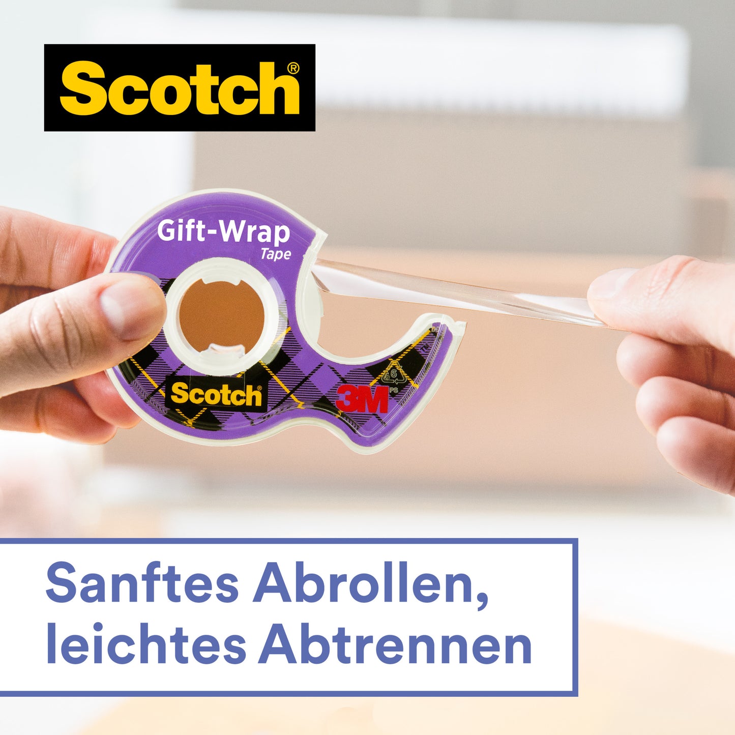 Eine Hand zieht das klare Scotch® Geschenk-Klebeband im Handabroller, CAT 15 (19 mm x 15 m) von 3M Deutschland GmbH ab. Text: "Sanftes Abrollen, leichtes Abtrennen." Unscharfer Hintergrund mit Büro- oder Wohnraum.