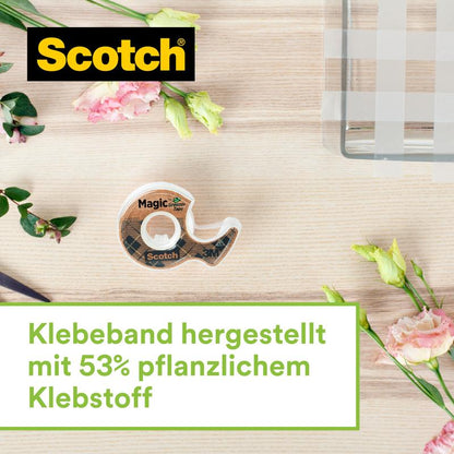 Ein Scotch™ Edelstahl-Klebebandabroller in Silber mit zwei Rollen Scotch® Magic™ Klebeband (hergestellt aus 66% pflanzenbasiertem Klebstoff, 19 mm x 13,9 m) von 3M Deutschland GmbH steht auf hellem Holz neben pinken und gelben Blumen.