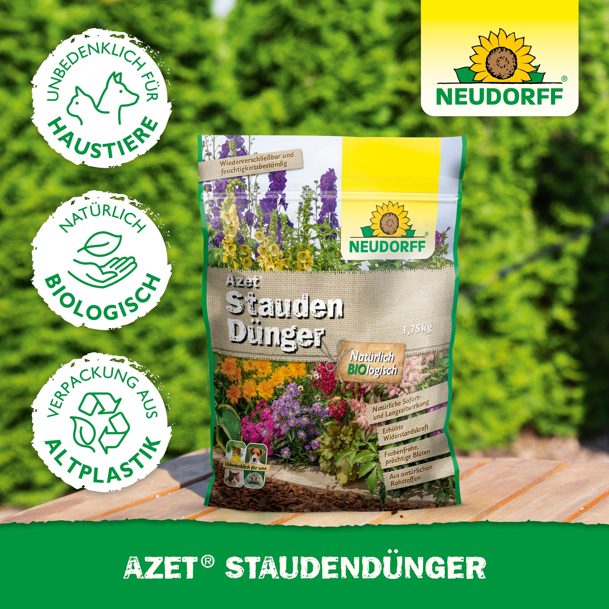 Ein Beutel Neudorff Shop Azet StaudenDünger, ein organischer, haustiersicherer Dünger aus recyceltem Kunststoff, liegt im Freien auf Holz mit verschwommenem grünen Laub - ideal für gesunde Stauden und Gärten.