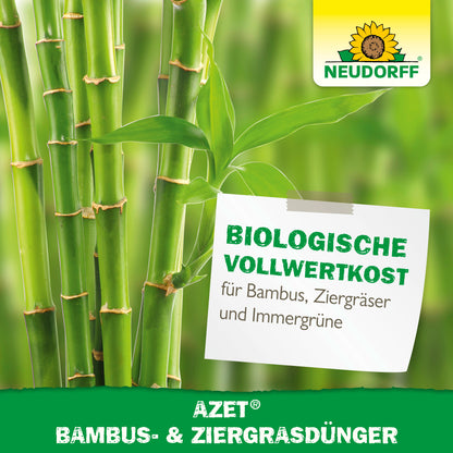Nahaufnahme von grünen Bambushalmen und Blättern mit dem Logo des Neudorff Shops. Auf einem Etikett steht: "Azet Bambus- & ZiergrasDünger - biologische Vollwertkost und pflegeleicht für Bambus, Gräser und Immergrüne.