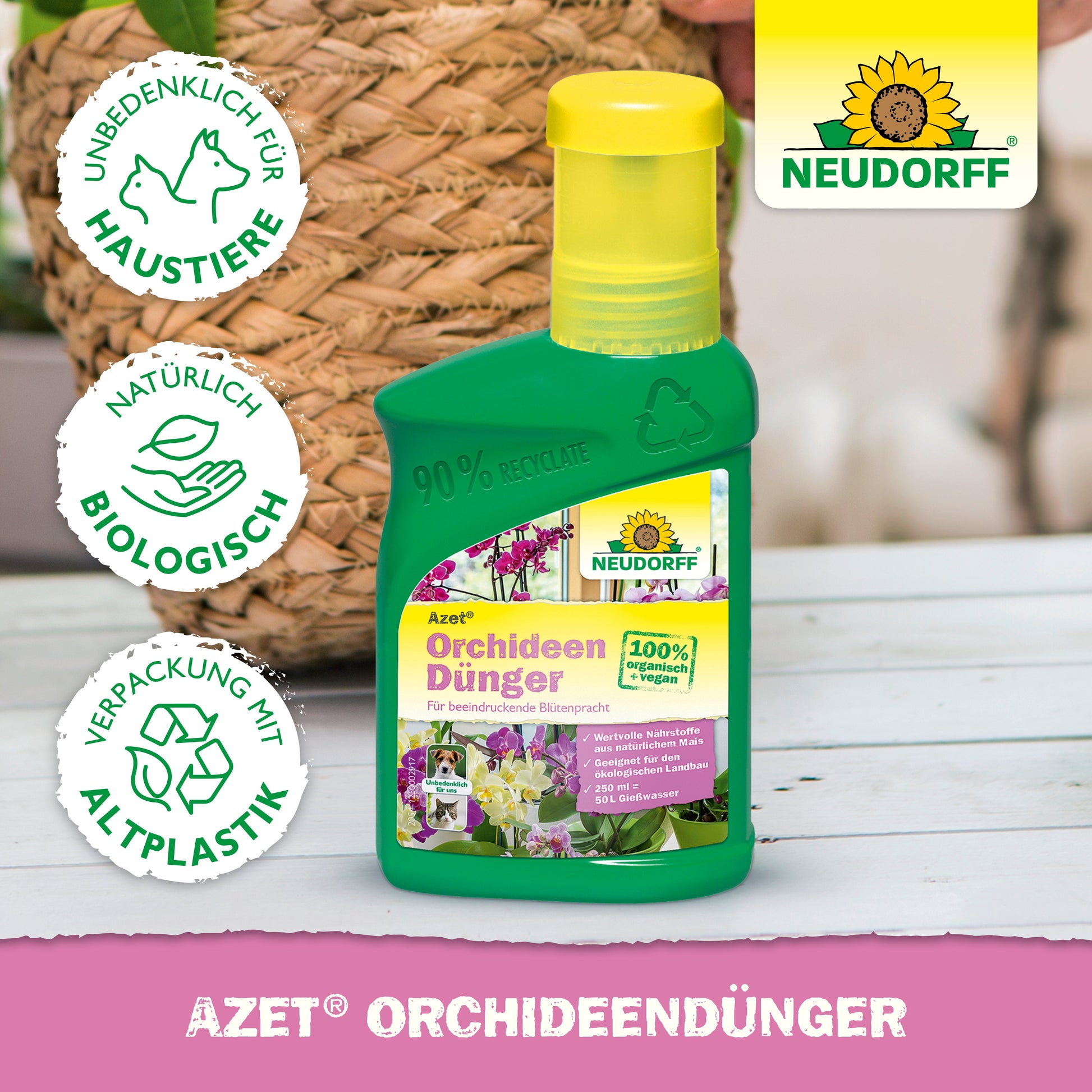 Eine grüne Flasche Azet OrchideenDünger flüssig von Neudorff Shop steht auf einer rosa Fläche. Sein Etikett aus 100% biologischem, haustiersicherem, recyceltem Kunststoff verspricht prächtige Blüten. Im Hintergrund sind ein geflochtener Korb und eine Pflanze zu sehen.