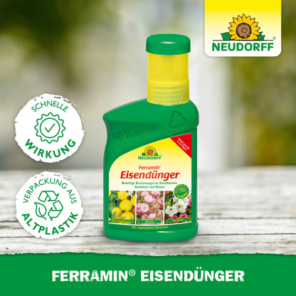 Eine grüne Plastikflasche mit Ferramin Eisendünger von Neudorff Shop steht auf einer Holzfläche. Auf dem Etikett sind Blumen und Zitronen abgebildet, es wirbt für eine schnelle Wirkung gegen Stickstoffmangel und weist darauf hin, dass es in recyceltem Plastik verpackt ist.