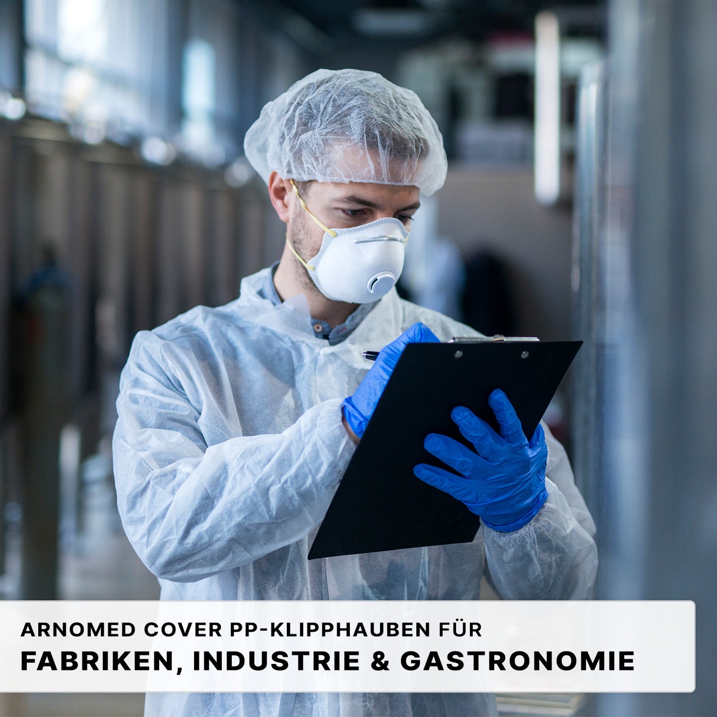 Eine Person in Schutzkleidung schreibt auf einem Klemmbrett in einer industriellen Umgebung. Der deutsche Text unten wirbt für ARNOMED COVER PP-KLIPPHAUBE XL (55cm, PP-Vlies) der ARNOWA GmbH für optimale Hygiene in Betrieben, Industrie und Gastronomie.