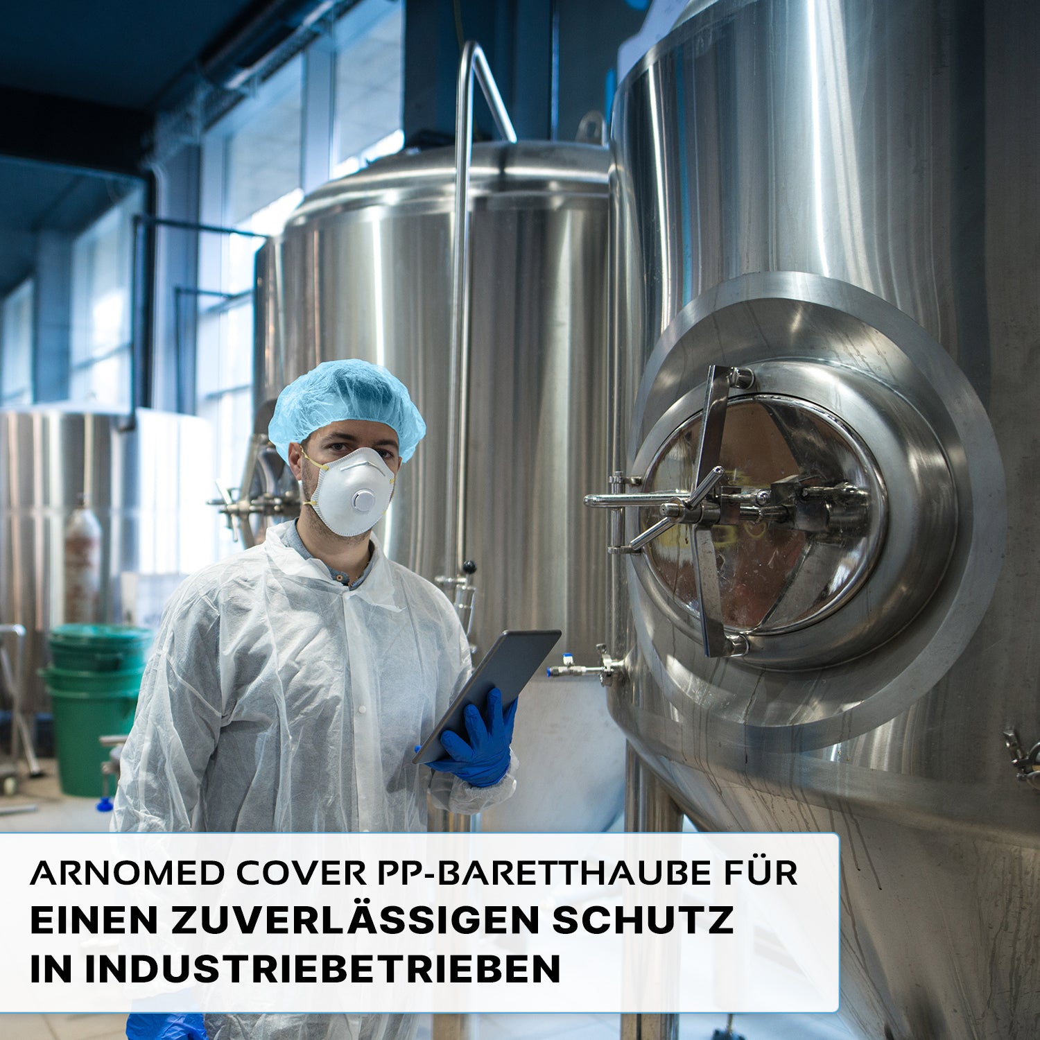 Eine Person, die eine ARNOMED COVER PP-BARETTHAUBE Baretthaube aus PP-Vlies der ARNOWA GmbH und eine Maske trägt, steht vor Edelstahltanks in einem industriellen Hygienebereich und hält ein Tablet in der Hand. Der deutsche Text hebt den zuverlässigen Schutz für die Industrie hervor.