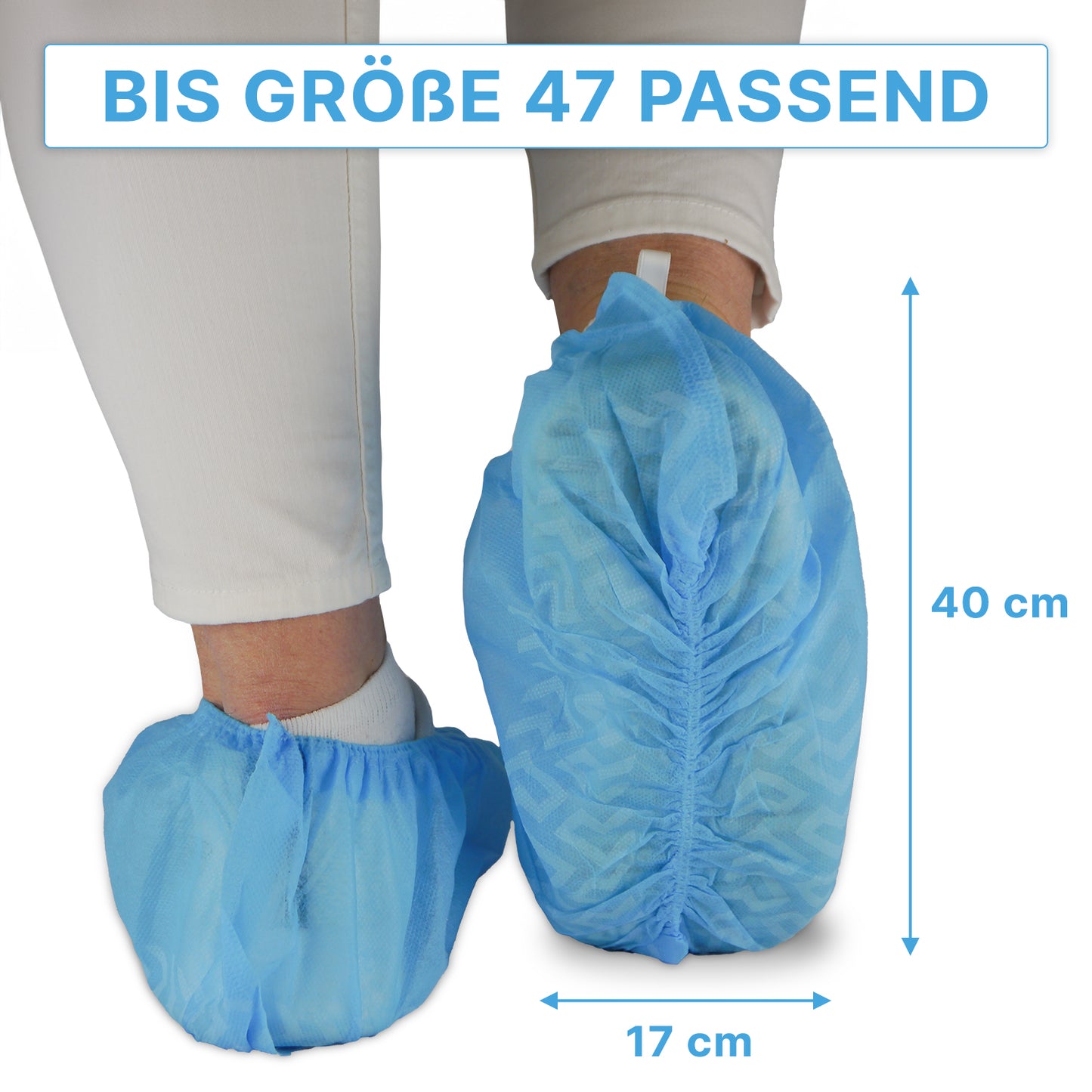 Une personne porte des surchaussures bleues ARNOMED ABS de ARNOWA GmbH par-dessus un pantalon blanc ; ces surchaussures jetables antidérapantes conviennent jusqu'à la taille 47 et mesurent environ 40×17 cm, comme indiqué par les flèches. Paquet : 100 pièces.
