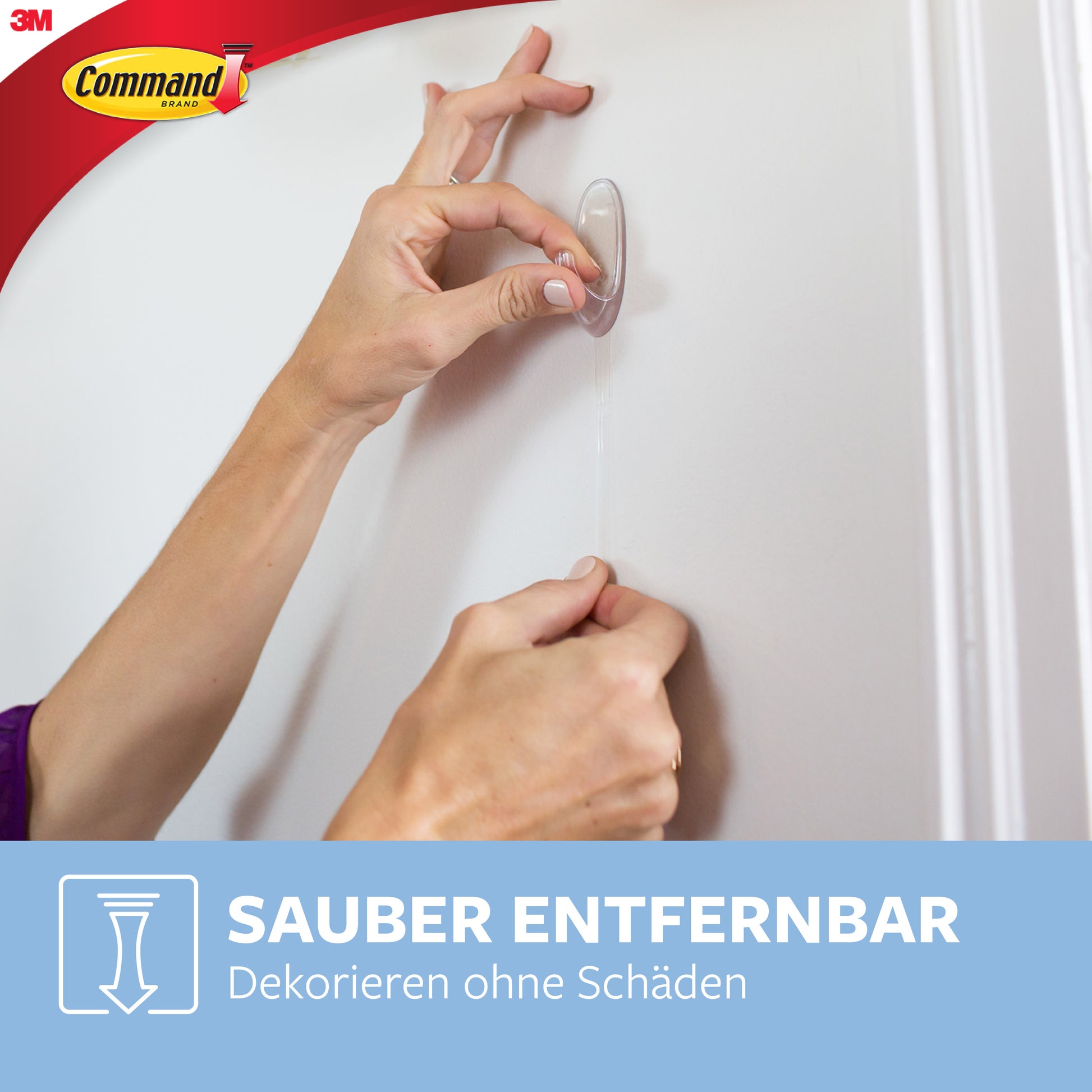 Eine Person entfernt einen transparenten Command™ Haken M (mittelgroß, 17091CLR) der 3M Deutschland GmbH mit Hilfe der Zuglasche von einer weißen Wand. Das Bild zeigt das Command-Logo und den deutschen Text zur beschädigungsfreien Entfernung.
