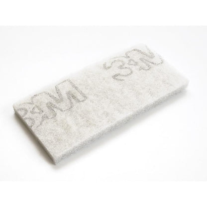 Un pad TASKI Jumbo blanc rectangulaire pour appareils de nettoyage de bords de Diversey Deutschland GmbH & Co. OHG, conçu pour le nettoyage professionnel, présente plusieurs logos gris "3M" et est illustré sur un fond blanc simple.