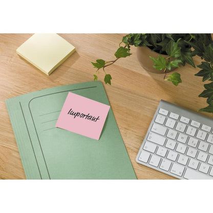 Un classeur vert avec une note de recyclage Post-it® de 3M Deutschland GmbH repose sur une table en bois à côté d'un clavier blanc, d'une note adhésive jaune et d'une plante en pot avec des feuilles vertes.
