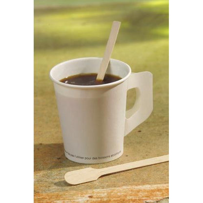 Ein weißer Einwegbecher mit dunklem Kaffee hält ein PAPSTAR Rührstäbchen Holz "pure" (13 cm), daneben ein weiteres umweltfreundliches Holzrührstäbchen der PAPSTAR GmbH. Der Hintergrund ist sanft verschwommen.