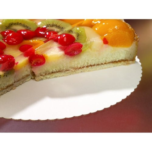 Sur un support à gâteaux rond et ondulé PAPSTAR 10 en carton "pur" de la PAPSTAR GmbH, repose un gâteau coupé garni de fruits, décoré de cerises, de kiwi et de tranches de pêche brillantes ; une partie du gâteau a été retirée.