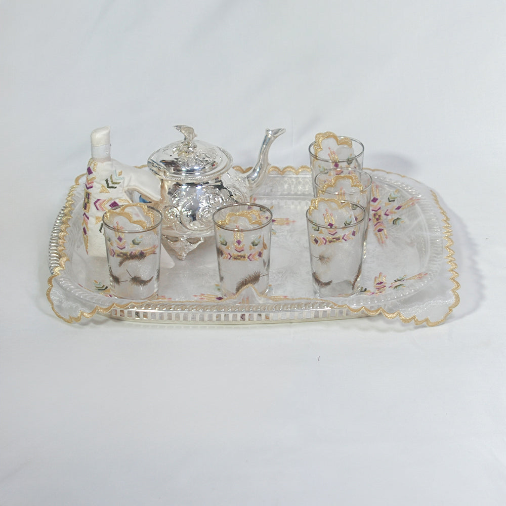 Eine Hand setzt oder entfernt eine weiße, runde LED-Kerze aus dem schwarzen Tablett des Duni GmbH LED Set, Warmweiß & Multicolor - 12 Stück Farbwechsel Leuchten; jede identische, wiederaufladbare Kerze sitzt auf einer Holzunterlage.