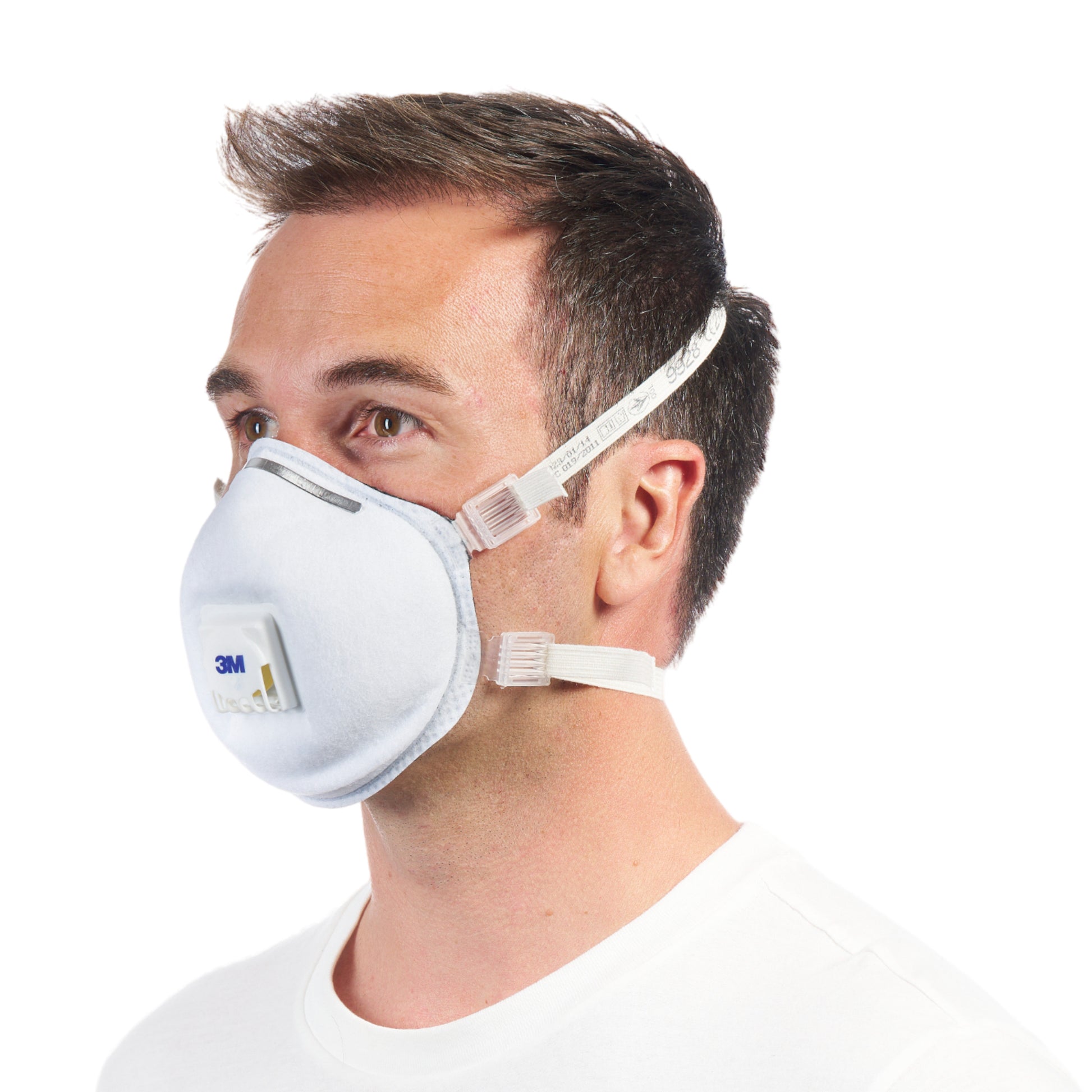 Ein Mann mit kurzen braunen Haaren trägt eine 3M™ Cool Flow™ Partikelmaske 9928 für Schweißarbeiten, mit Ventil (1 Stück) von 3M Deutschland GmbH, in der Seitenansicht vor einem schlichten weißen Hintergrund.