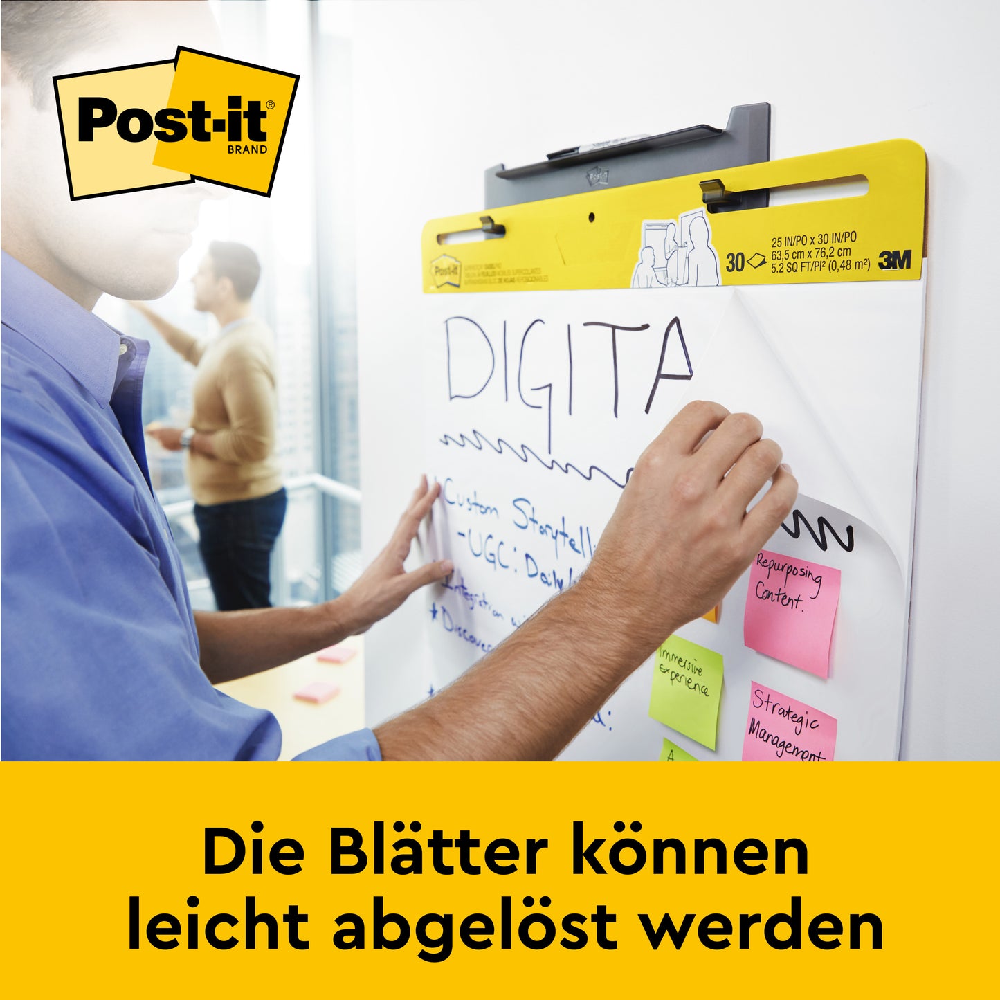 Eine Person schreibt auf ein 3M Deutschland GmbH Post-it® Super Sticky selbsthaftendes Meeting Chart/Flipchart für Wand-Montage 566 (58,4 x 50,8 cm, weiß), das mit Command™-Streifen an einem Whiteboard befestigt ist; bunte Haftnotizen sind darauf angebracht.