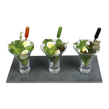Trois verres avec de la salade et des œufs sont posés sur un plateau en ardoise. Chaque verre contient une pipette Starpak 100, une pipette PE transparente en orange, vert et noir pour une application précise de la vinaigrette.