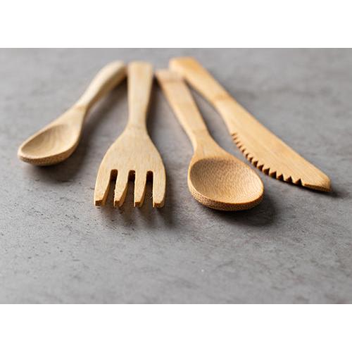 Zehn umweltfreundliche PAPSTAR Bambusgabeln "pure" (16,5 cm) von PAPSTAR GmbH sind nebeneinander auf einer grauen Oberfläche ausgebreitet.