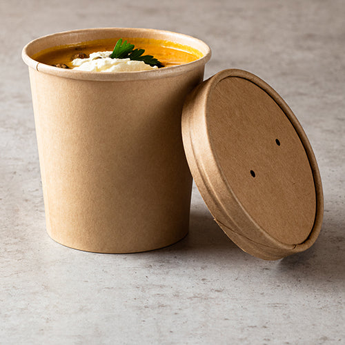 Le gobelet à soupe Starpak 25, carton rond Ø 11,5 cm brun, est idéal pour les soupes à emporter - ici rempli de soupe orange, garni de crème et de persil, sur une surface grise avec un couvercle assorti.
