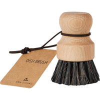 La brosse à casseroles ENA Living à poils souples, proposée par Abena Re-Seller GmbH, est dotée d'une tête ronde en bois, d'un manche court, d'une dragonne en cuir et d'une étiquette « DISH BRUSH » : elle est idéale pour un nettoyage en douceur de la cuisine. Disponible en carton de 12 paquets.