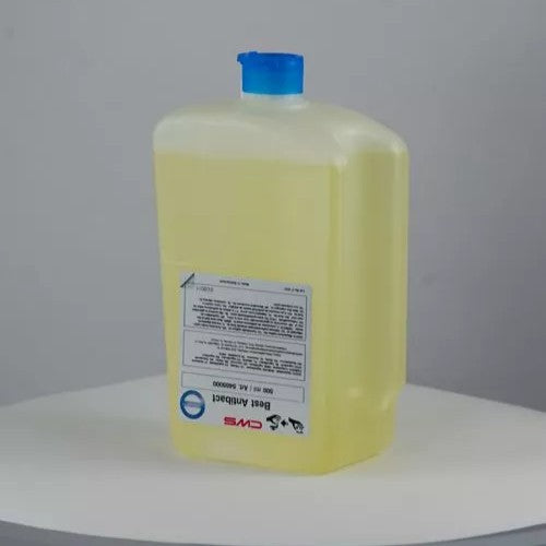 Une bouteille rectangulaire et transparente de 500 ml de crème de savon CWS Best Antibact avec un bouchon bleu et du savon jaune se trouve sur une surface ronde et blanche. L'étiquette avant souligne les avantages des soins de la peau.