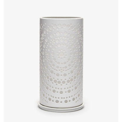 Un vase cylindrique blanc avec un motif de points concentriques perforés moderne, rappelant le photophore Billy en métal de Duni GmbH, se trouve devant un fond blanc simple.