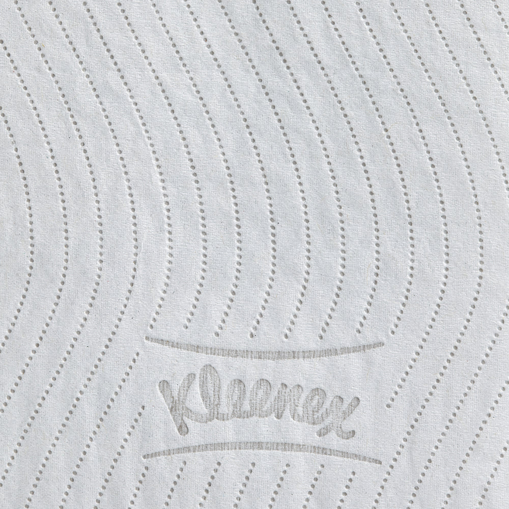 Die Nahaufnahme einer weißen Kleenex® Toilettenpapierrolle der Kimberly-Clark GmbH zeigt gepunktete, gewellte Linien und den in Grau geprägten Schriftzug "Kleenex", der die hochwertige Textur dieses 8er-Kartons (12 kleine Rollen à 250 Blatt) hervorhebt.