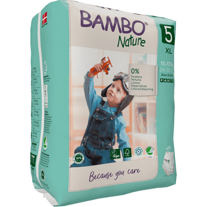 Un emballage de Bambo Nature Pants de la société Abena Re-Seller GmbH, taille 5 XL (11-17 kg), montre un enfant en salopette avec un avion jouet. L'emballage écologique met en avant les caractéristiques respectueuses de la peau et de l'environnement.