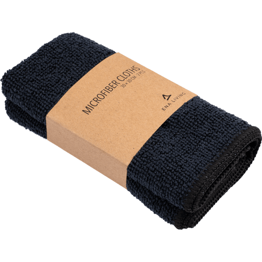 Un lot de deux chiffons en microfibre ENA Living noirs (30 x 30 cm) de la marque Abena Re-Seller GmbH, chacun plié et muni d'une étiquette marron portant la mention « Microfiber Cloths 30 x 30 cm » ainsi qu'un logo minimaliste – idéaux pour être utilisés comme chiffons de ménage.