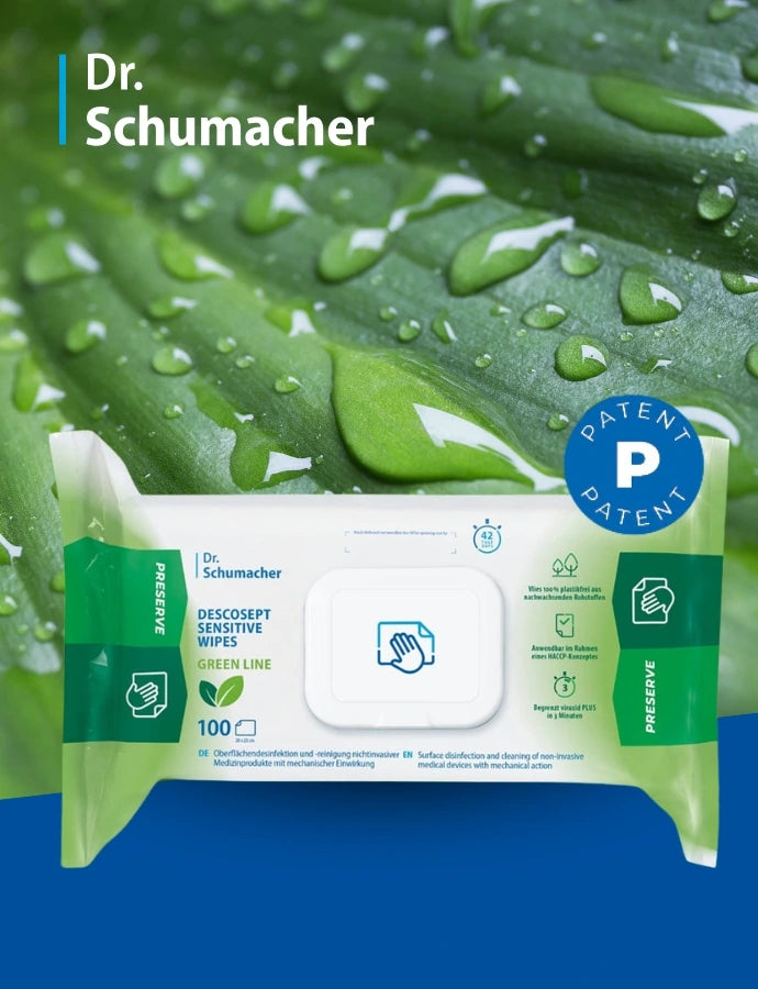 Werbegrafik von Dr. Schumacher für „Descosept Sensitive Wipes Green Line“: Vor einem Hintergrund aus grünen Blättern mit Wassertropfen ist eine Packung Desinfektionstücher mittig abgebildet. Links steht auf blauem Hintergrund das Logo „Dr. Schumacher“, rechts oben ein rundes blaues „Patent“-Siegel. Auf der Verpackung sind Produktname, ein Symbol mit Hand und Tuch sowie Hinweise zur nachhaltigen „Green Line“ und zur Anwendung zu sehen.