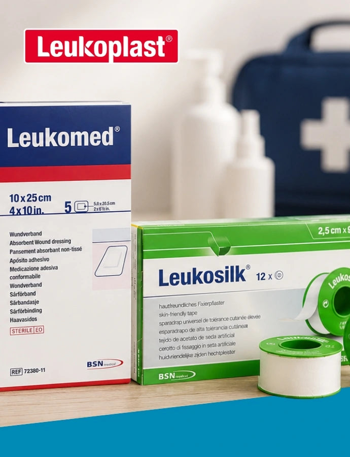 BSN medical Produkte zur professionellen Wundversorgung: Fixomull stretch Fixierpflaster, Leukomed Wundverband und Leukosilk Rollenpflaster vor einem Erste-Hilfe-Set.