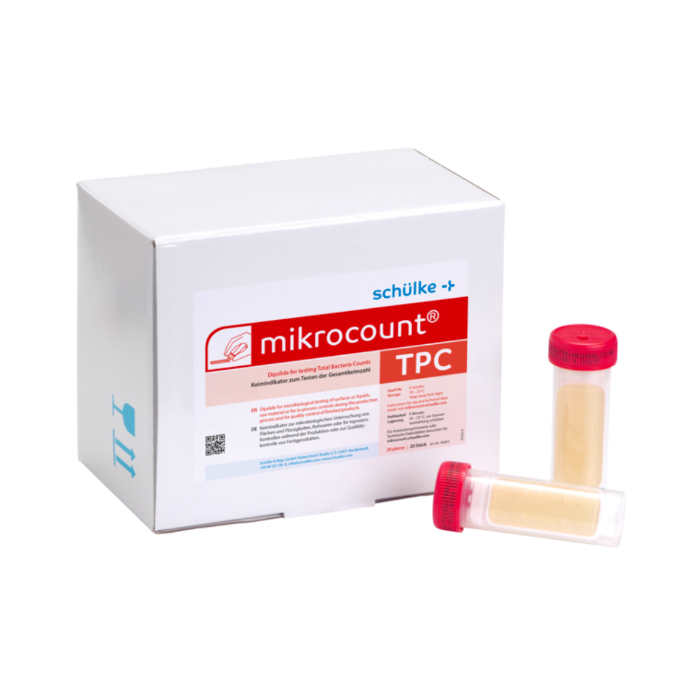 Une boîte blanche avec l'inscription « Schülke & Mayr GmbH Mikrocount® TPC, milieu de culture | Emballage (20 pièces) » avec un logo et une description du produit à côté de deux flacons pour tests microbiens, l'un avec un bouchon jaune, l'autre avec un bouchon transparent.