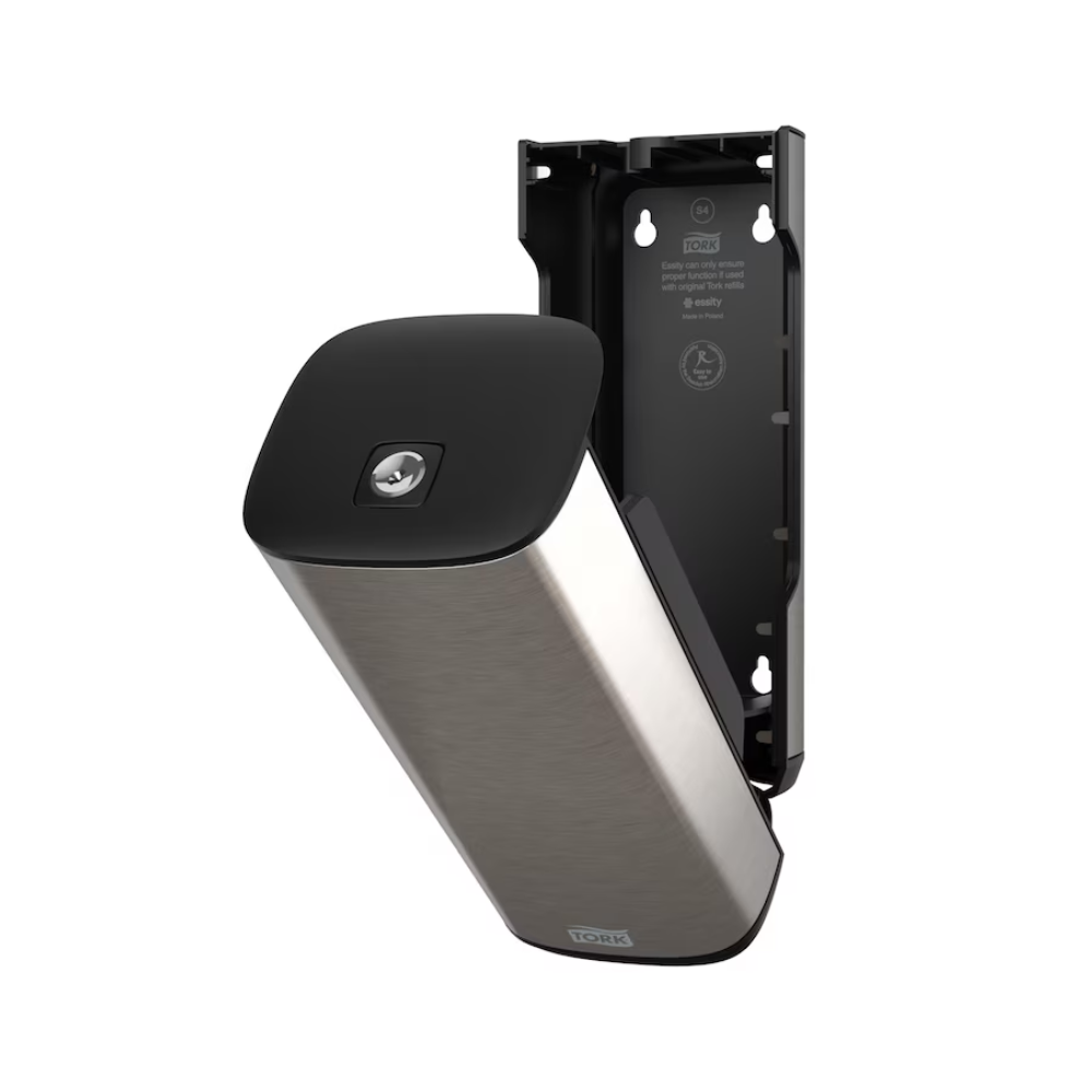 Un distributeur Tork 460010 pour savon et désinfectant pour les mains en acier inoxydable et noir de Essity Professional Hygiene Germany GmbH pour montage mural avec une façade ouverte qui révèle l'intérieur. Ce design moderne présente également une plaque partiellement détachée qui expose le support intérieur et les positions des vis.