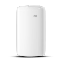 Dieser Tork 564000 Mini-Abfallbehälter Elevation 5 Liter B3 von Essity Professional Hygiene Germany GmbH ist ein weißer, zylindrischer Abfallbehälter mit dem Tork-Logo auf der Vorderseite. Er bietet ein glattes und sauberes Design, das mit seinen hygienischen Abfallentsorgungseigenschaften jeden Raum aufwertet und aus langlebigem Kunststoff gefertigt zu sein scheint.