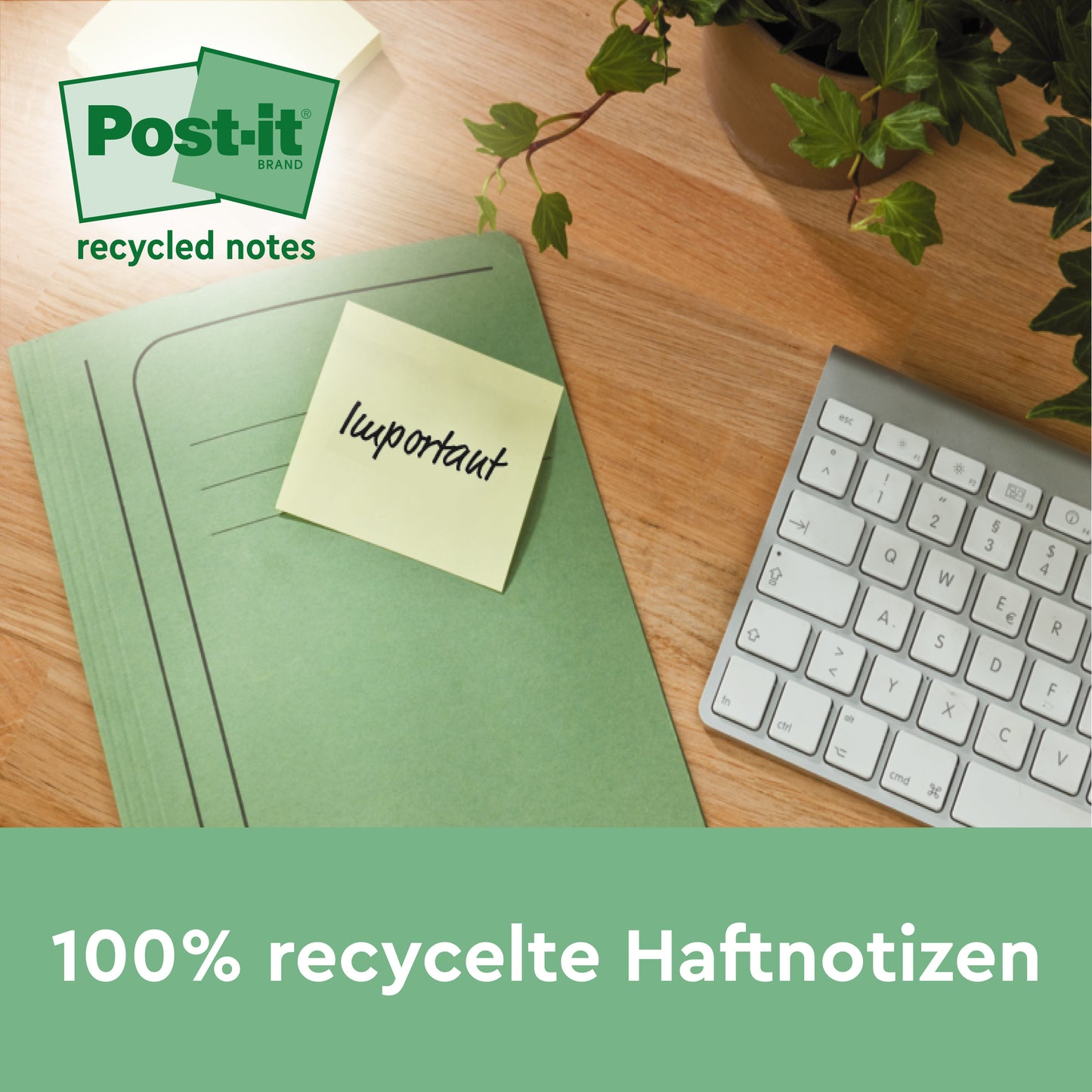 Eine grüne Mappe mit einer Post-it® Super Sticky 100% Recycling Note der 3M Deutschland GmbH mit der Aufschrift "wichtig" liegt auf einem Schreibtisch neben einer Tastatur und einer Pflanze. Der Text lautet: "100% recycelte Haftnotizen, 76 x 76 mm, 70 Blatt/Block, PEFC-zertifiziert.
